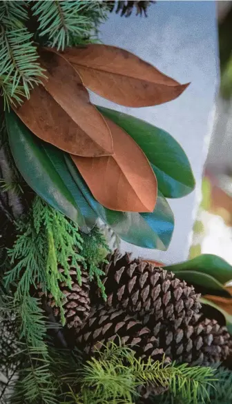  ?? Photos by Marie D. De Jesús / Staff photograph­er ?? Holiday garland made out of fresh evergreen branches, magnolia leaves and pine cones on the mantel of a kitchen fireplace helps make the room inviting for the holidays.