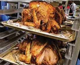  ?? STAFF PHOTO BY RACHEL MURRAY ?? Volunteers at the House of Bread in Dayton prepare turkeys, pies and all the fixings, in advance of Thanksgivi­ng Day 2015.