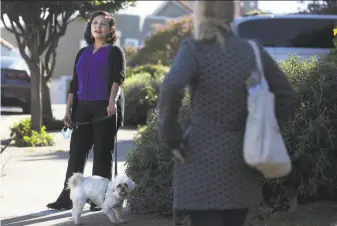  ?? Liz Hafalia / The Chronicle 2020 ?? New San Francisco Supervisor Myrna Melgar chats with a neighbor while walking her dog. One of Melgar’s earliest memories is the turmoil of a 1979 El Salvador military coup.