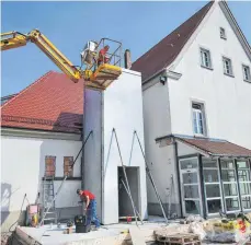  ?? FOTO: AFI ?? Der rund 25 Tonnen schwere Aufzugscha­cht, hergestell­t aus Betonferti­gteilen, ist am Dorfhaus Eggenrot angebracht worden. Bis Mittwochmi­ttag, so der Vorarbeite­r der Firma Hans Fuchs, Klaus Oesterle (im Hubwagen), soll alles für den weiteren Ausbau fertig sein.