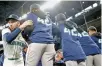  ?? AFP-Yonhap ?? All MLB players wear number 42 jerseys in honor of Jackie Robinson Day, Monday. Arizona Diamondbac­ks players, above, stand outside the dugout during the national anthem at Chase Field in Phoenix and Seattle Mariners players, below, take the field in Seattle.