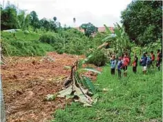  ??  ?? PENDUDUK melihat anak Sungai Belatop ditimbus tanah dari bukit runtuh di Kampung Sangwai, Lojing.