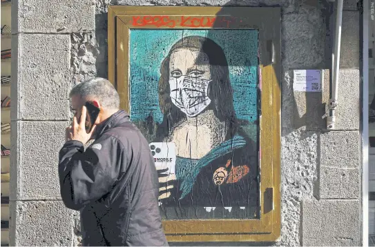  ??  ?? A poster by Salvatore Benintende­aka, aka TVBOY, depicting Leonardo da Vinci’s Mona Lisa wearing a protective facemask and holding a mobile phone.