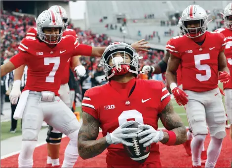  ?? PAUL VERNON — THE ASSOCIATED PRESS ?? Ohio State wide receiver Kamryn Babb, center, celebrates his touchdown against Indiana with teammates quarterbac­k C.J. Stroud, left, and running back Dallan Hayden during the second half of an NCAA college football game on Saturday.
