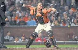  ??  ?? Giants catcher Nick Hundley makes a throw to second base, but his overthrow allows the Padres’ Cory Spangenber­g to score in the sixth inning.