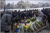  ?? EMILIO MORENATTI — THE ASSOCIATED PRESS ?? Relatives place flowers at the grave of Yevhen Zapotichny­i, a Ukrainian military servicemen, during his funeral in Lviv, Ukraine, on Tuesday.