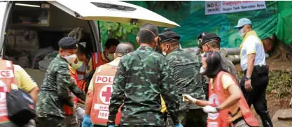  ?? —AFP PHOTO ?? RACE AGAINST TIME AND WATER Thai soldiers and paramedics assist a rescued boy on a stretcher to an ambulance in Tham Luang cave area.