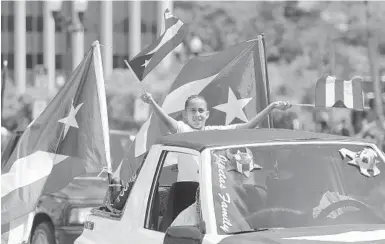  ?? SENTINEL TOMAS DINIZ SANTOS/ORLANDO ?? Paraders cheer and wave during the Florida Puerto Rican Parade in downtown Orlando on Saturday.