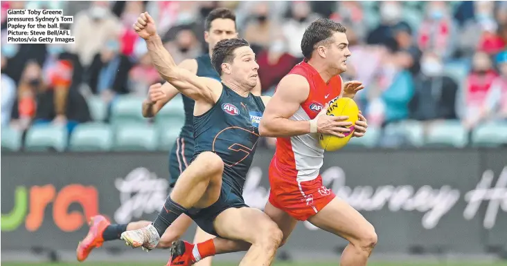  ??  ?? Giants’ Toby Greene pressures Sydney’s Tom Papley for the ball. Picture: Steve Bell/AFL Photos/via Getty Images