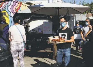  ?? Photos by Yalonda M. James / The Chronicle ?? Eric Chow of Astranda delivers cinnamon rolls to Magnolia Mini Mart in Oakland as a line of people await.