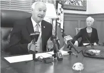  ?? Associated Press ?? Arkansas Gov. Asa Hutchinson speaks to the media Thursday about a drop in the number of people enrolled in the state’s Medicaid program.