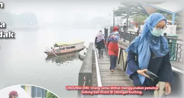  ??  ?? LINDUNGI DIRI: Orang ramai dilihat menggunaka­n penutup
hidung dan mulut di Tebingan Kuching.