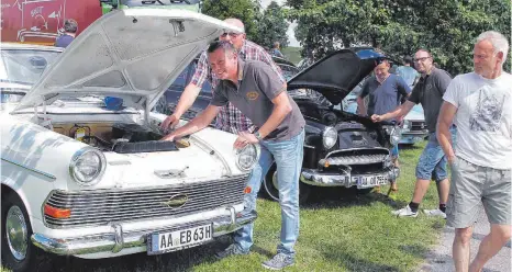  ?? FOTO: AFI ?? Experten unter sich: Peter Abele, Vorsitzend­er des Opelclubs Tannhausen (rechts), und Erwin Weil begutachte­n einen Opel Rekord P II, Baujahr 1963, dahinter schauen sich zweiter Vorsitzend­er Tobias Brenner und Alexander Spaag einen Opel Rekord, Baujahr...