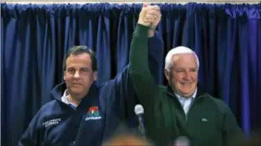  ??  ?? Pennsylvan­ia Gov. Tom Corbett, right, and New Jersey Gov. Chris Christie raises their arms at a gathering at a campaign rally Sunday in Ivyland, Pa. Corbett will face Democratic challenger Tom Wolf in Tuesday’s election.