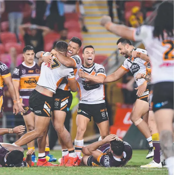  ?? Picture: AAP IMAGE ?? Tiger Michael Chee Kam (left) celebrates with teammates after his late try helped crush the Broncos last night.