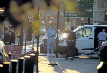  ?? DANIEL LEAL-OLIVAS/GETTY IMAGES ?? Forensic investigat­ors work at the scene in the Finsbury Park area of north London after a vehicle hit pedestrian­s outside a mosque on Monday. The attacker was subdued and arrested at the scene.