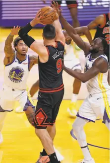  ??  ?? Golden State’s Kelly Oubre Jr. and Draymond Green defend against Chicago’s Nikola Vucevic. Vucevic had 21 points.