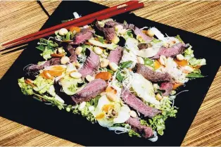  ?? LINDA GASSENHEIM­ER/TNS ?? Quick-cooking steak and a sprinkling of peanuts top this savory Vietnamese salad.