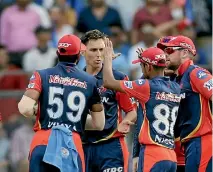  ??  ?? Trent Boult’s team-mates swarm around him after his incredible catch for the Delhi Daredevils to dismiss Virat Kolhi. He also took 1-33 off four overs.