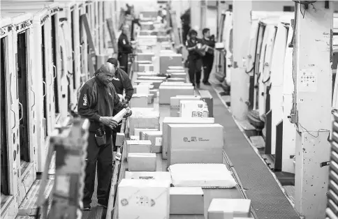  ??  ?? Employees sort packages for delivery at the FedEx Corp. shipping centre in Chicago on Nov 27. The holiday shopping season is off to a strong start and retailers appear to be continuing the momentum – Cyber Monday – the biggest online spending day of...