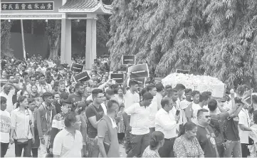  ??  ?? Family members and friends escorting Nhaveen’s coffin to the cremation centre. — Bernama photo