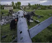  ?? BERNAT ARMANGUE — THE ASSOCIATED PRESS ?? Oleksiy Polyakov, right, and Roman Voitko check the remains of a destroyed Russian helicopter in a field in the village of Malaya Rohan, Kharkiv region, Ukraine, Monday.