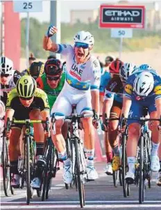  ?? AFP ?? UAE Team Emirates’ Alexander Kristoff (in white) celebrates as he crosses the finish line in Stage 1 of the Abu Dhabi Tour.