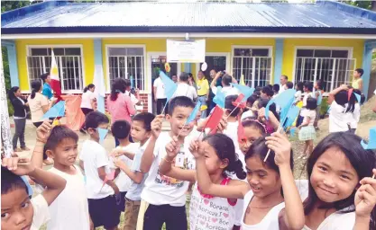  ?? (SUN.STAR FOTO/ARNI ACLAO) ?? HAPPY. Schoolchil­dren of Bogo-Kawasan Elementary School in Aloguinsan cheer after the formal turnover of the two-classroom schoolbuil­ding from the Provincial Government.