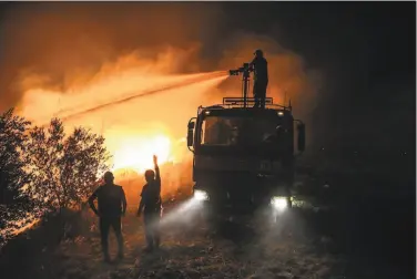  ?? Associated Press ?? Firefighte­rs in Turkey fight to get a wildfire under control in the village of Kirli in Antalya province. Crews battled at least 14 blazes Friday burning in six provinces. Dozens of homes were incinerate­d.