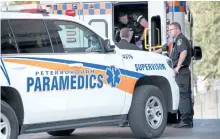  ?? JASON BAIN/EXAMINER ?? Paramedics tend to an injured man who showed up at Peterborou­gh Police Service headquarte­rs on Water St. after an altercatio­n in an apartment at nearby Water and London streets on Tuesday.