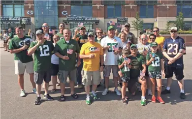  ??  ?? Diane Malecki and her family and friends brought American flags to the Packers game Sunday to counter protests from players.