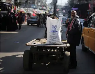  ?? (Ibraheem Abu Mustafa/Reuters) ?? A MAN STANDS next to a cart carrying a flour sack distribute­d by UNRWA in the Khan Yunis refugee camp in the southern Gaza Strip last week.