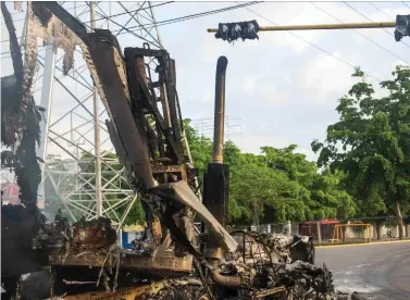  ?? AP Photo/Augusto Zurita ?? ■ A burnt-out truck used by gunmen smolders at an intersecti­on Friday a day after street battles between gunmen and security forces in Culiacan, Mexico. Mexican security forces backed off an attempt to capture a son of imprisoned drug lord Joaquin “El Chapo” Guzman after finding themselves outgunned in a ferocious shootout with cartel enforcers that left at least eight people dead and more than 20 wounded, authoritie­s said.