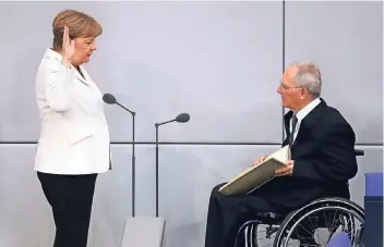  ?? FOTOS: DPA ?? Zum ersten Mal nimmt Bundestags­präsident Wolfgang Schäuble Angela Merkel den Amtseid ab.