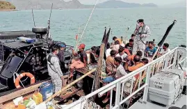  ??  ?? Malaysian navy officers detaining a boat carrying a group of Rohingya Muslim migrants seeking refuge off Langkawi, Malaysia, this month. The Rohingya are denied citizenshi­p in their home country of Myanmar.