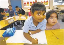  ?? Allen J. Schaben Los Angeles Times ?? JAYDEN SOTO and Ashley Meneses work on an assignment at Sunrise Elementary, whose enrollment decline opened up classroom space for Excelencia.