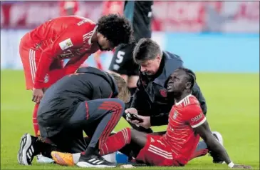  ?? ?? El cuerpo médico del Bayern atiende a Mané sobre el césped ante la atenta mirada de Gnabry.