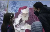  ?? TED S. WARREN — THE ASSOCIATED PRESS ?? Santa, portrayed by Dan Kemmis, talks to a family as he sits inside a protective bubble in Seattle’s Greenwood neighborho­od.