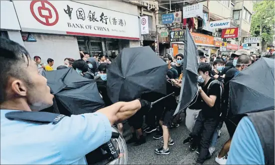  ?? KIN CHEUNG / AP ?? Policías y manifestan­tes forcejean en Hong Kong, donde las protestas siguen pese a la suspensión del proyecto de ley de extradició­n