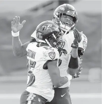  ?? ANDY LYONS/ GETTY ?? QB Lamar Jackson, right, and WR Marquise Brown celebrate after the Ravens’ comeback victory over the Titans on Sunday.