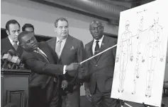  ?? Associated Press photos ?? ■ LEFT: Pathologis­t Dr. Bennet Omalu, second from left, gestures Friday at a diagram showing where police shooting victim Stephon Clark was struck by bullets as he speaks during a news conference in Sacramento.