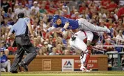  ?? JEFF ROBERSON / AP ?? The Blue Jays’ Chris Coghlan takes a flying leap over Cardinals catcher Yadier Molina to land on home plate and score for a 3-2 lead.