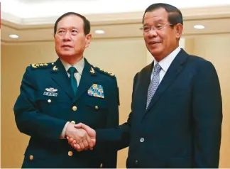  ??  ?? 中國國防部長魏鳳和（左）此前在金邊與柬埔寨首­相洪森握手。(路透資料照片)