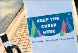  ??  ?? Keep the cheer here” signs around downtown Homewood encourage shopping locally.