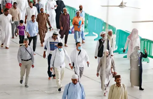  ?? Agence France-presse ?? ↑
Worshipper­s, some of them wearing protective masks, walk around Makkah’s Grand Mosque on Friday.