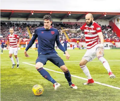  ??  ?? Blocking move Hamilton’s Georgios Sarris tries to stop Kyle Lafferty from attacking