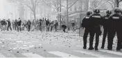  ?? LEWIS JOLY AP ?? Demonstrat­ors throw stones toward police officers during a protest against the recent shooting at the Kurdish culture center in Paris on Saturday. Kurdish activists, left-wing politician­s and anti-racism groups held a protest after three people were killed at a Kurdish cultural center in an attack aimed at foreigners.