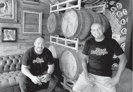  ?? MIKE STOCKER/ SOUTH FLORIDA SUN SENTINEL ?? Black Flamingo Brewing Company co-owner Andres Wolff, left, and brewer Manny Jannes in the taproom at their Pompano Beach location on Oct. 8. Their brewery is in expansion mode, and will debut its second taproom this month in downtown Oakland Park.