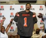  ?? NATHAN HUNSINGER — THE ASSOCIATED PRESS ?? Texas A&M’s Myles Garrett holds up a Cleveland Browns jersey as his mother, Audrey Garrett, left, cheers with Bruce Smith, right, after Garrett was taken as the No. 1 pick in the NFL Draft at Terre Verde Golf Course in Arlington, Texas on Thursday.