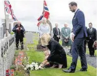  ??  ?? The royal couple lay flowers at the graves of Norwegian sailors who died in World War II